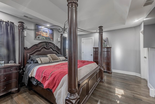 bedroom featuring dark wood-type flooring and a tray ceiling