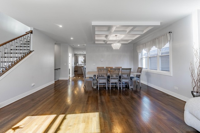 dining space with an inviting chandelier, dark hardwood / wood-style floors, coffered ceiling, and beamed ceiling