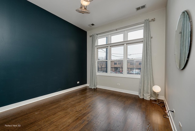 empty room featuring dark wood-type flooring and plenty of natural light