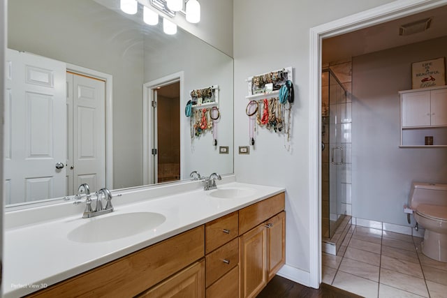 bathroom with tile patterned flooring, an enclosed shower, vanity, and toilet