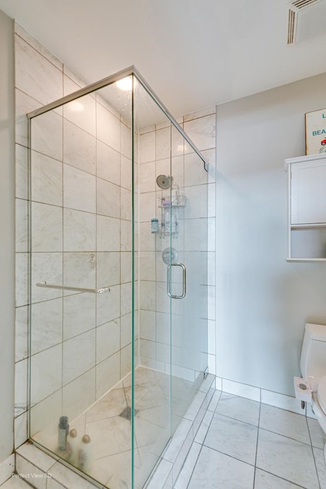 bathroom featuring toilet, tile patterned flooring, and walk in shower