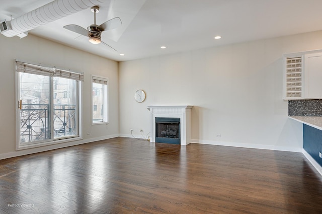 unfurnished living room featuring ceiling fan and dark hardwood / wood-style floors