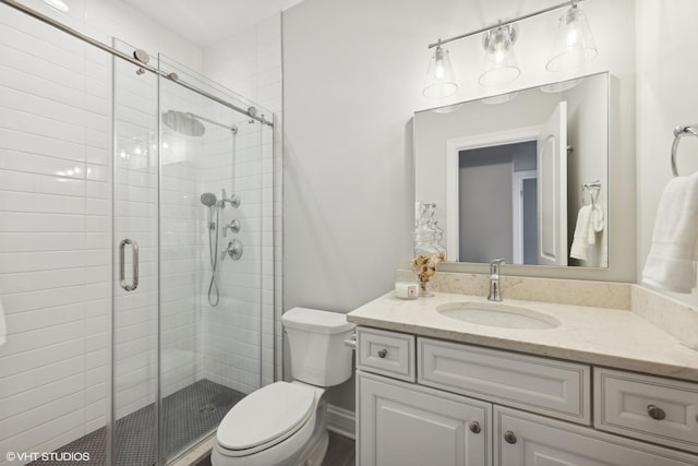 bathroom with vanity, toilet, and a shower with shower door