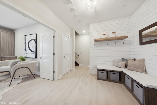 mudroom with wooden walls and light hardwood / wood-style flooring