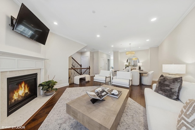 living room featuring a premium fireplace, dark hardwood / wood-style floors, and ornamental molding