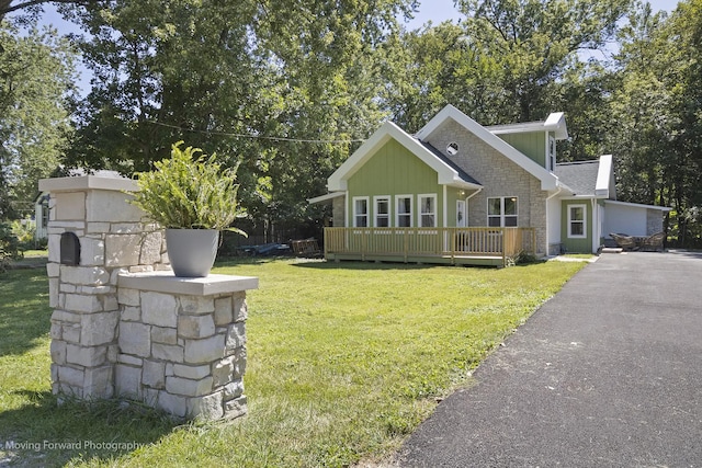 view of front of home featuring a front yard, a deck, and a garage