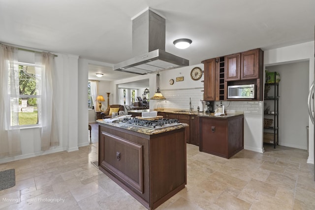 kitchen featuring island exhaust hood, appliances with stainless steel finishes, a healthy amount of sunlight, and sink