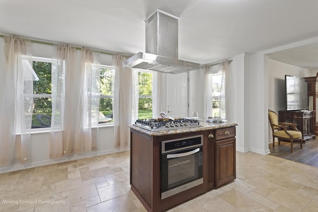 kitchen featuring island exhaust hood, stainless steel appliances, a kitchen island, and plenty of natural light