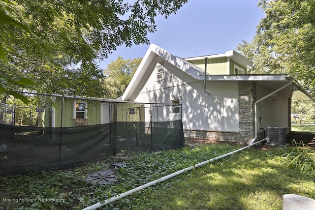 view of property exterior with a lawn and central air condition unit