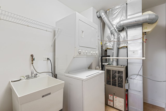 washroom with stacked washer and dryer and sink