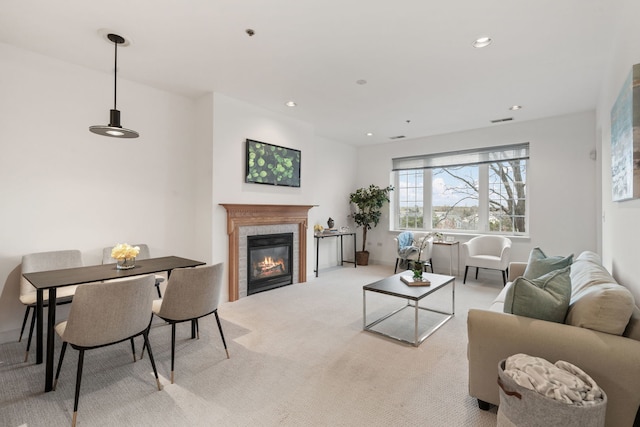 living room featuring light carpet and a tiled fireplace