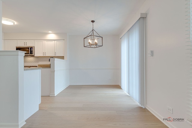 interior space featuring a notable chandelier and light wood-type flooring