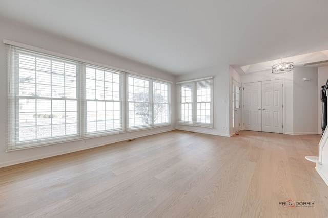 unfurnished living room with plenty of natural light and light hardwood / wood-style flooring