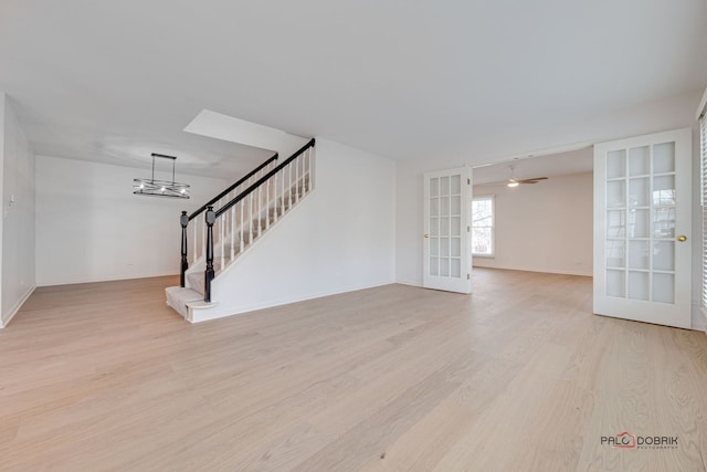 unfurnished living room featuring french doors and light hardwood / wood-style flooring