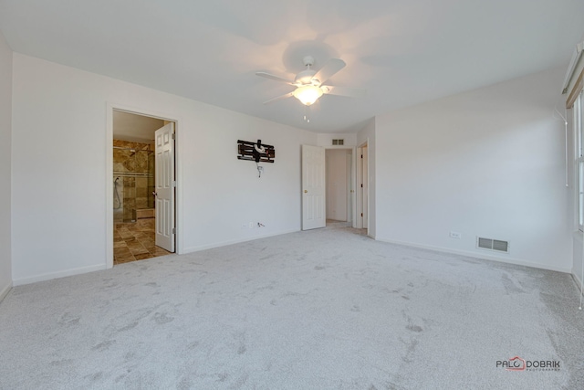 interior space with carpet flooring, ceiling fan, and connected bathroom