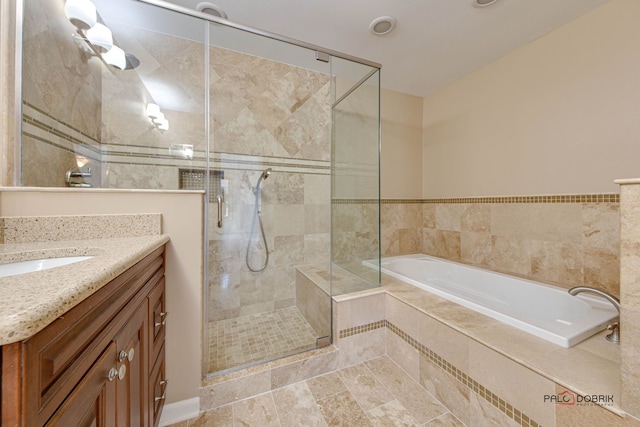 bathroom featuring plus walk in shower, vanity, and tile patterned flooring