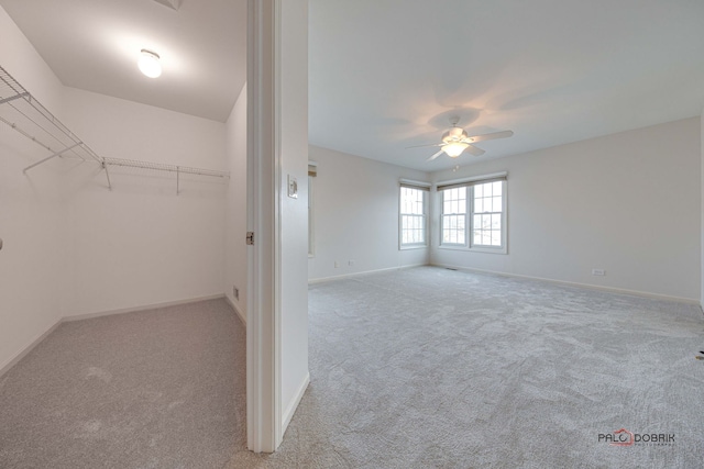 interior space with light carpet and ceiling fan