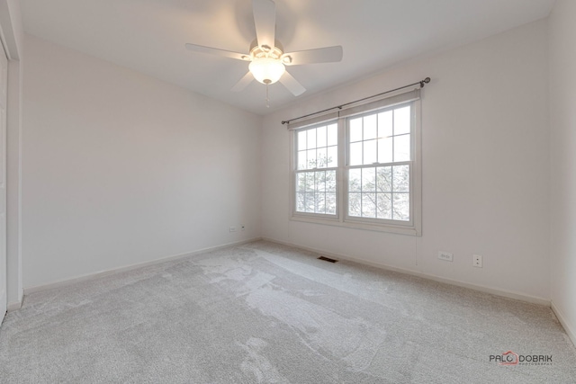 empty room with ceiling fan and light colored carpet