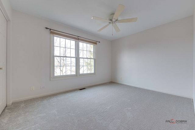 spare room with ceiling fan and light carpet