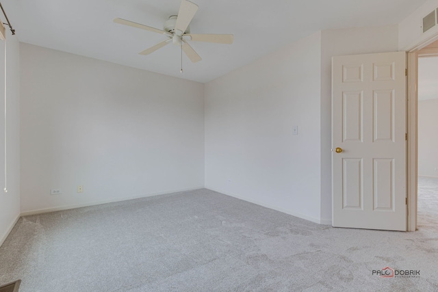 spare room with ceiling fan and light carpet