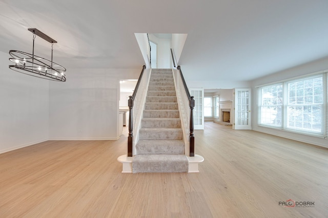 stairway featuring hardwood / wood-style floors and a chandelier