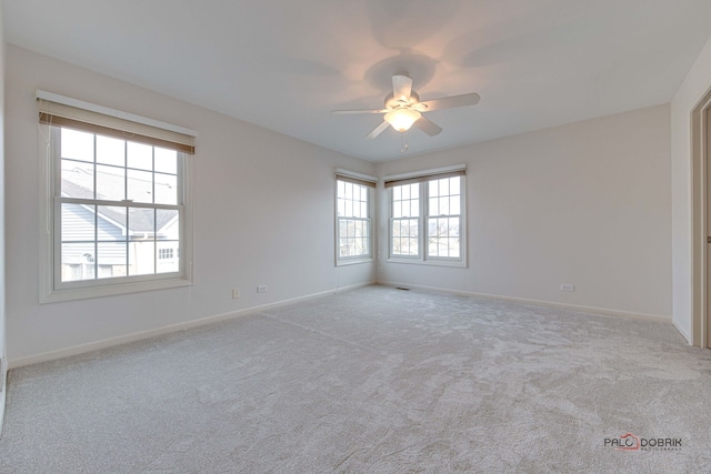 spare room with ceiling fan and light carpet