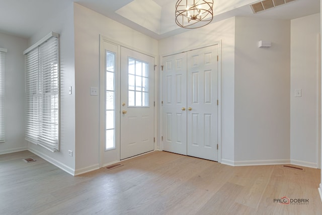 entrance foyer featuring light hardwood / wood-style floors and a notable chandelier