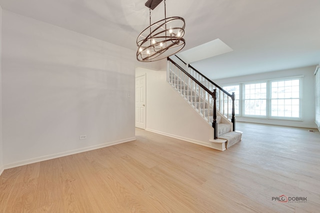 unfurnished living room featuring light hardwood / wood-style flooring and an inviting chandelier