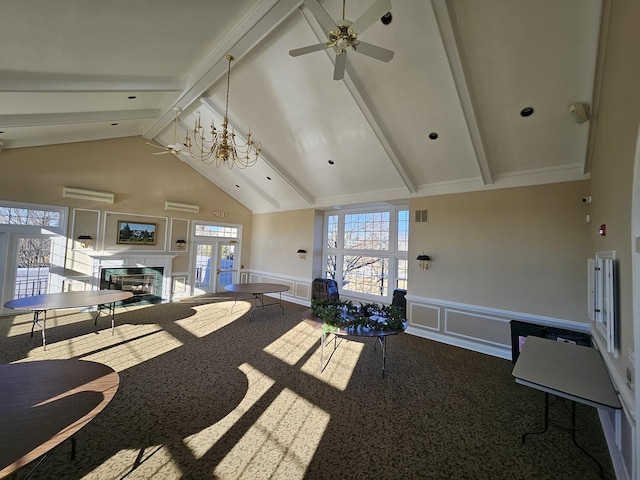 interior space featuring beamed ceiling, ceiling fan with notable chandelier, and a healthy amount of sunlight