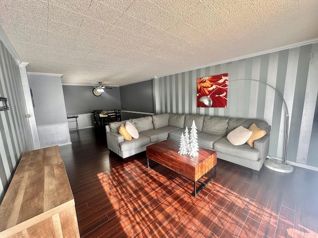 living room with dark hardwood / wood-style flooring, ceiling fan, and crown molding