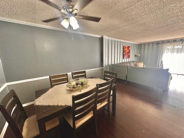 dining area featuring a textured ceiling, ceiling fan, crown molding, and dark wood-type flooring