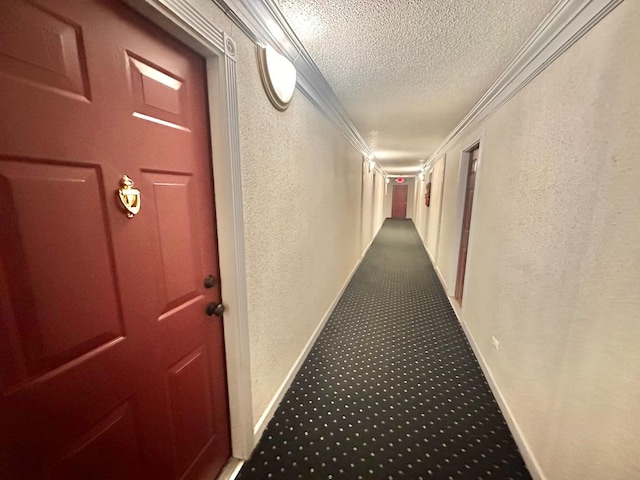 corridor with carpet flooring, ornamental molding, and a textured ceiling