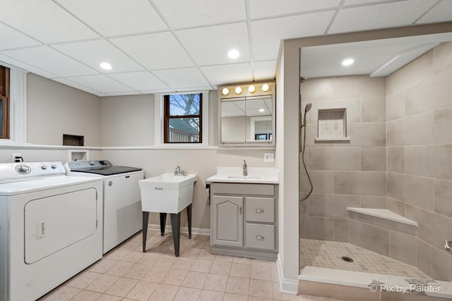 laundry area featuring sink, light tile patterned floors, and washer and clothes dryer