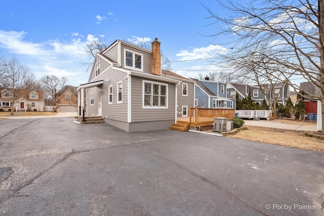 exterior space featuring central AC unit, a garage, and a deck