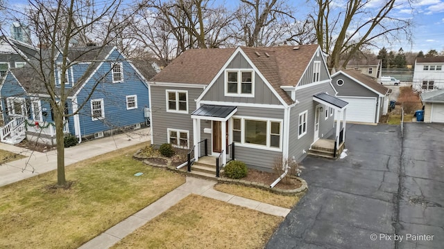 view of front facade with a garage, an outdoor structure, and a front lawn