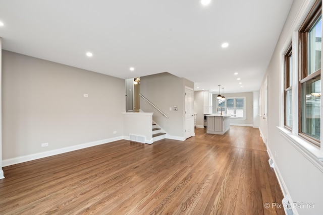 unfurnished living room featuring sink and light hardwood / wood-style flooring