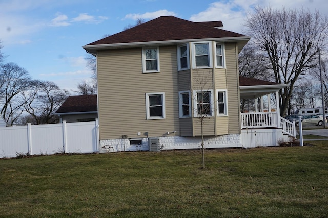 back of house featuring cooling unit and a lawn