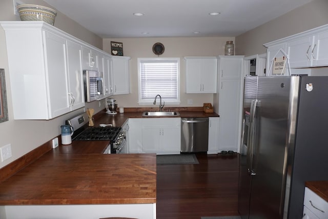 kitchen featuring dark hardwood / wood-style floors, sink, white cabinets, wooden counters, and stainless steel appliances