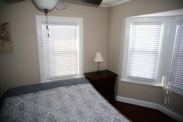 bedroom featuring crown molding and dark wood-type flooring