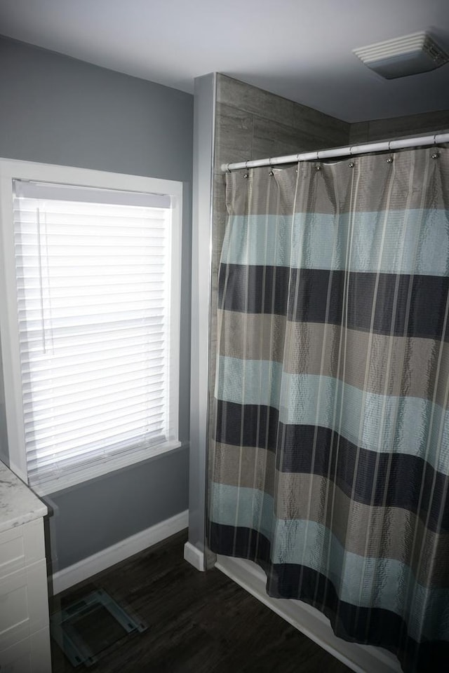 bathroom featuring hardwood / wood-style flooring and walk in shower