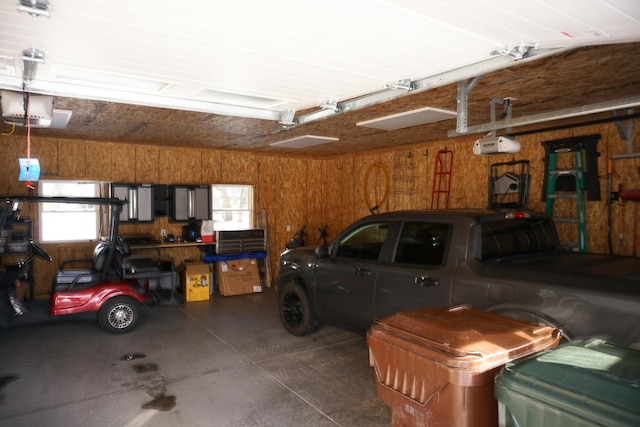 garage featuring a garage door opener and wooden walls