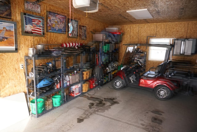 garage featuring a garage door opener and wood walls