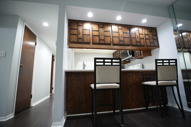 bar with dark hardwood / wood-style flooring