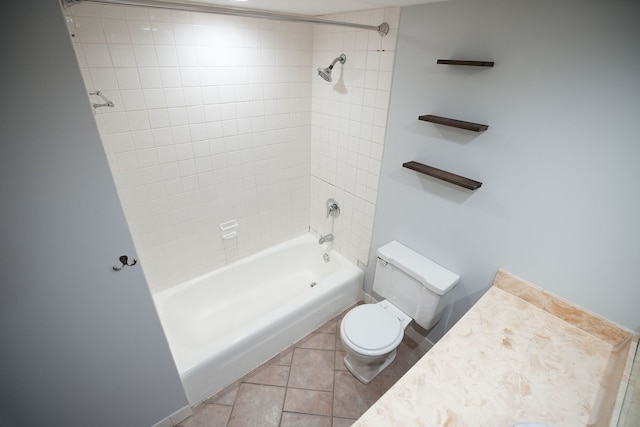 bathroom with tile patterned floors, toilet, and tiled shower / bath