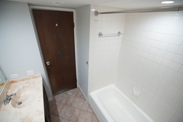 bathroom with tile patterned flooring, vanity, and tiled shower / bath