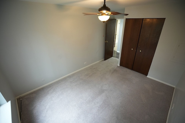 unfurnished bedroom featuring ceiling fan, light carpet, and a closet