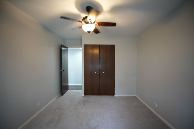 unfurnished bedroom with ceiling fan, a closet, and light carpet