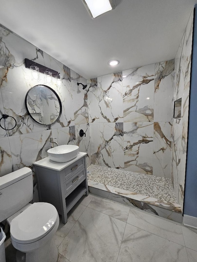 bathroom with toilet, tile walls, walk in shower, and vanity