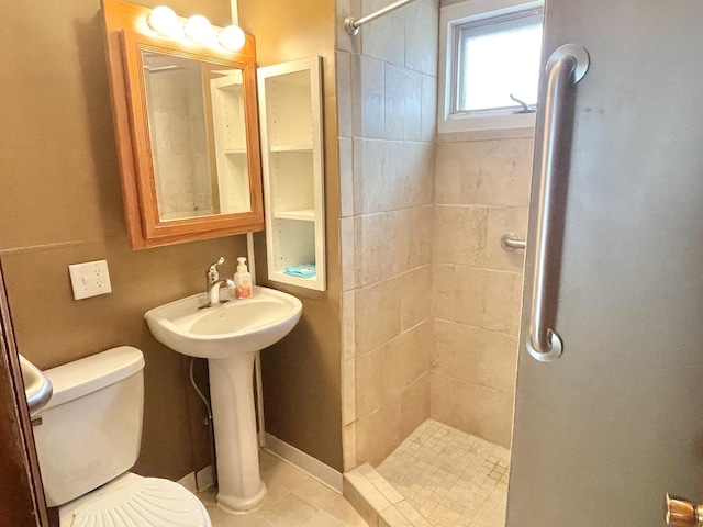 bathroom featuring tile patterned floors, toilet, and tiled shower