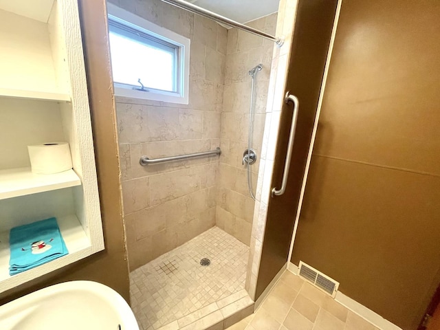 bathroom featuring tiled shower and tile patterned floors